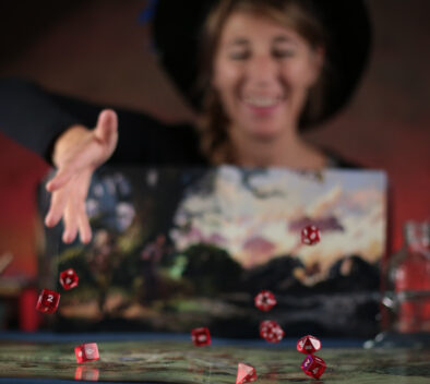 Femme portant un chapeau et lançant des dés sur un plateau de jeu de société