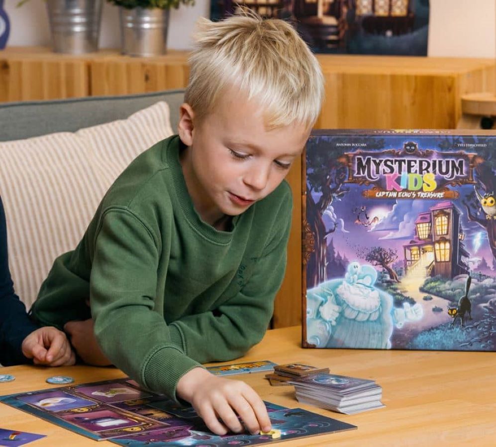 Enfant jouant au jeu de société Mysterium Kids