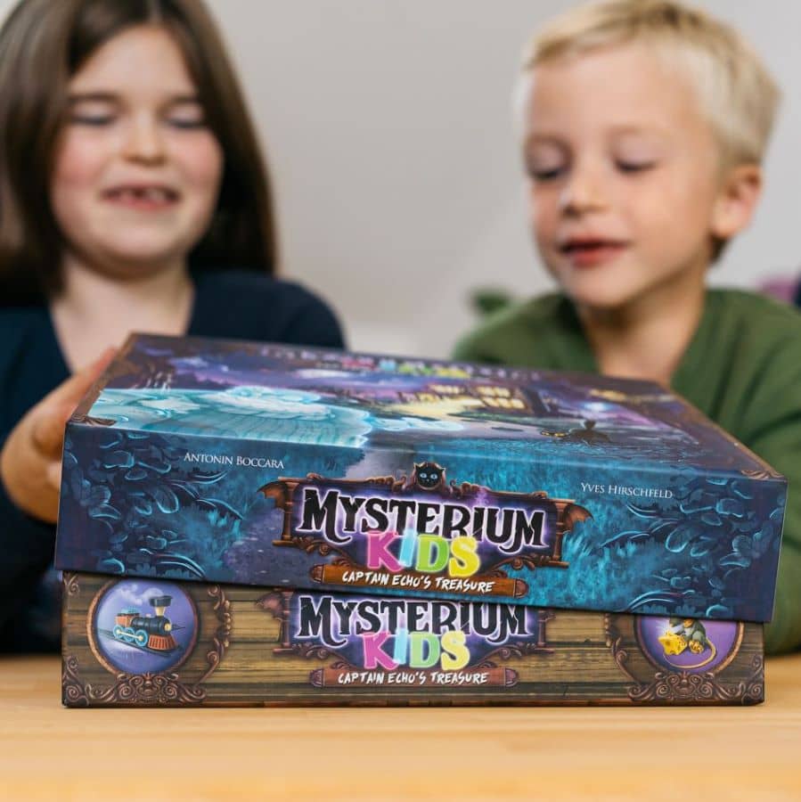 Enfants devant une boîte du jeu de société Mysterium Kids