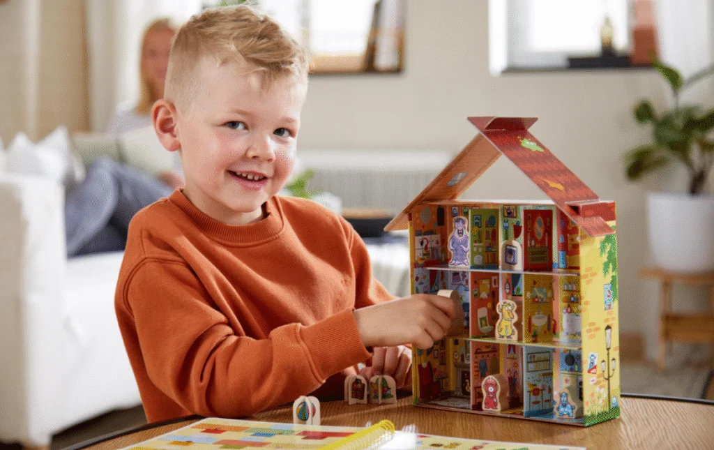 Un petit garçon se trouve à côté de la maison de Wanda le petit monstre rouge.