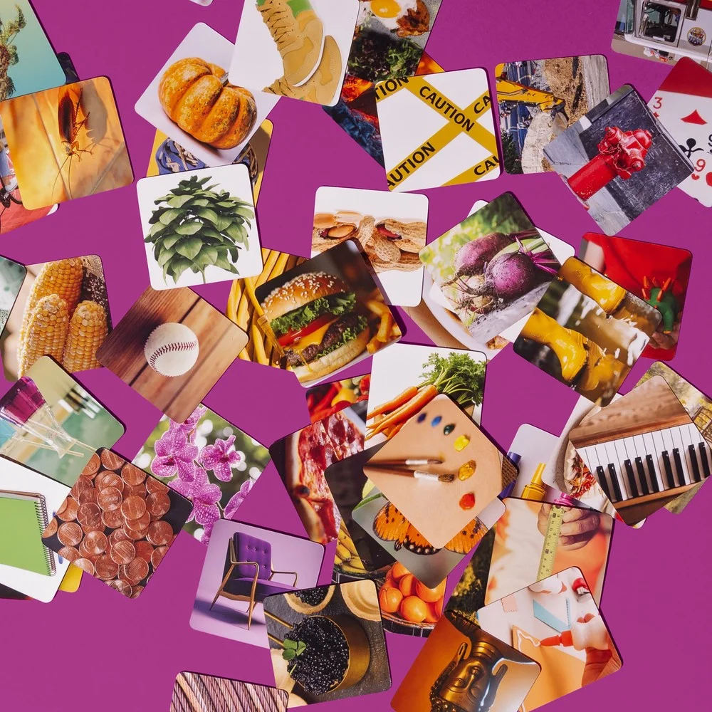 Moodbox Games Guess the Mess photo cards scattered on a purple background for a fast family party board game.
